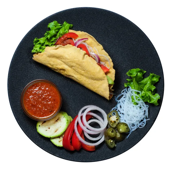 Üst Manzara. İçi besleyici ve siyah tabakta salsa soslu sıcak taco.