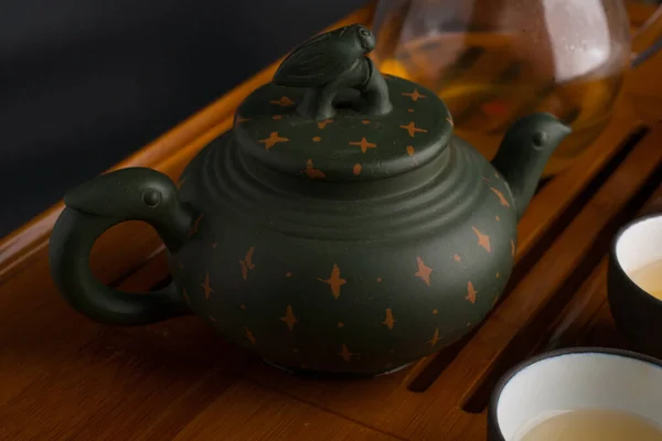 Kapağında ağustos böceği ve çay seremonisi için aksesuarları olan yeşil geleneksel Çin kil çaydanlığı. — Stok fotoğraf