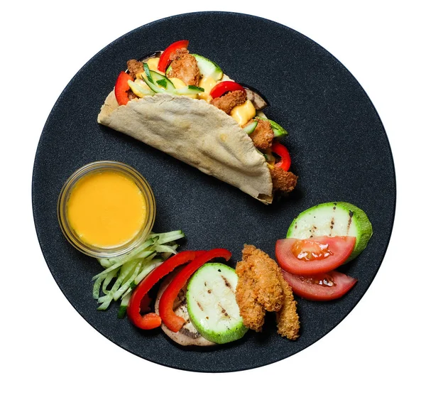 Üst Manzara. İçi besleyici ve siyah tabakta salsa soslu sıcak taco.