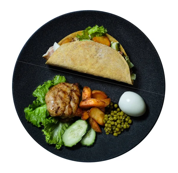 Tavuklu, etli, sebzeli ve siyah tabaktaki malzemeli taco.