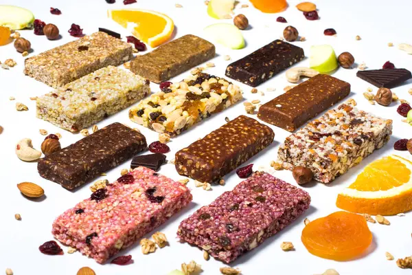 Mısır gevreği ve beyaz arka planda fındıklı protein barları ve kuru meyve meyveleri ile kompozisyon