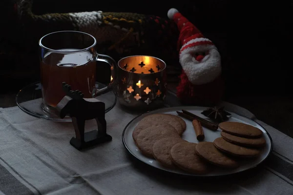 Christmas breakfast. Tea and gingerbread cookies plate, candle andsoft toy Santa — Stock Photo, Image