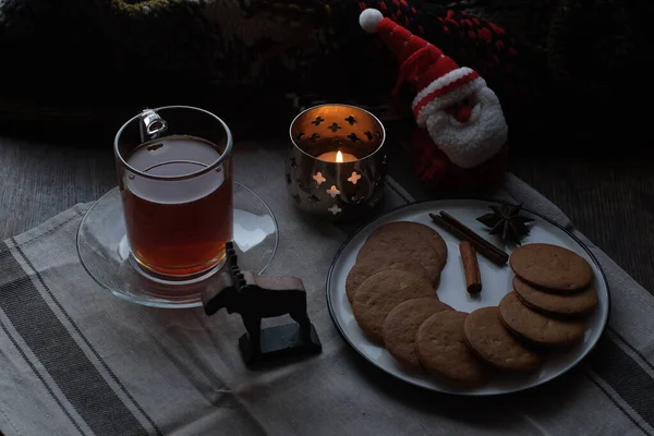 Christmas breakfast. Tea and gingerbread cookies plate, candle andsoft toy Santa — Stock Photo, Image