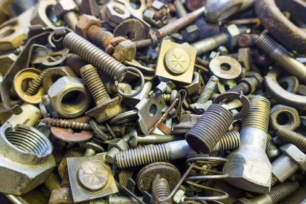 Mix of rusty auto scrap including nuts, bolts, springs, washers, cotter pins, collected in the old metallic can.