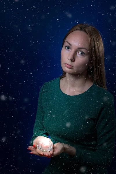 Elinde mum tutan sevimli genç bir kadın. Kış, Noel ve maneviyat kavramı.