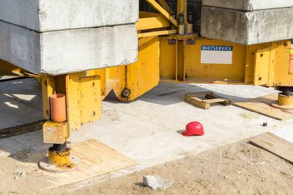 base plate of a crane with balance weight - red helmet on the ground