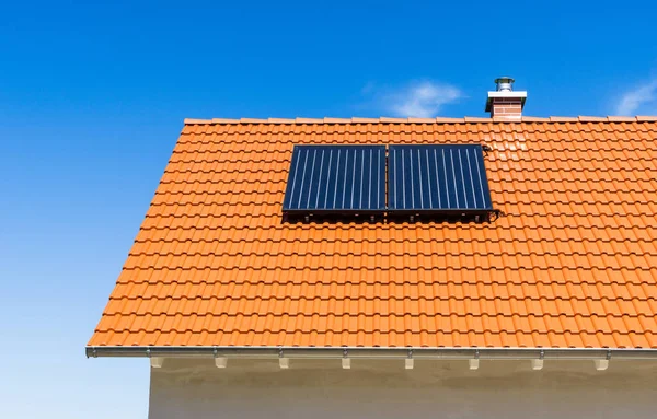 roof of a house with solar thermal plant - blue sky