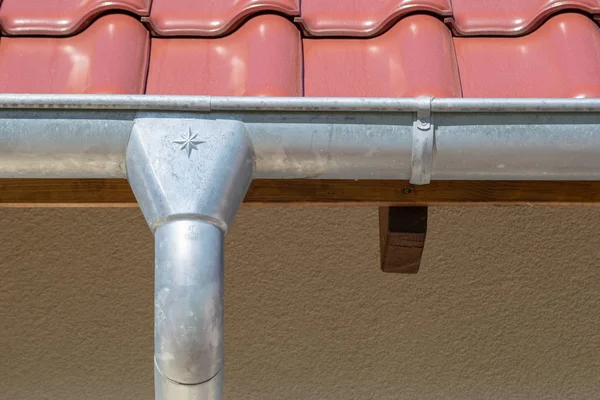 gutter or roof gutter - red tiles on a roof