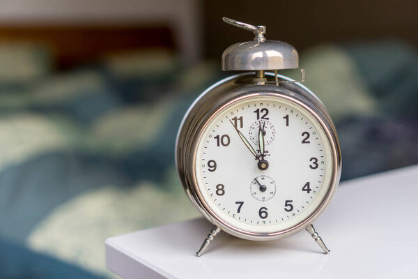 будильник на тумбочке рядом с кроватью
 