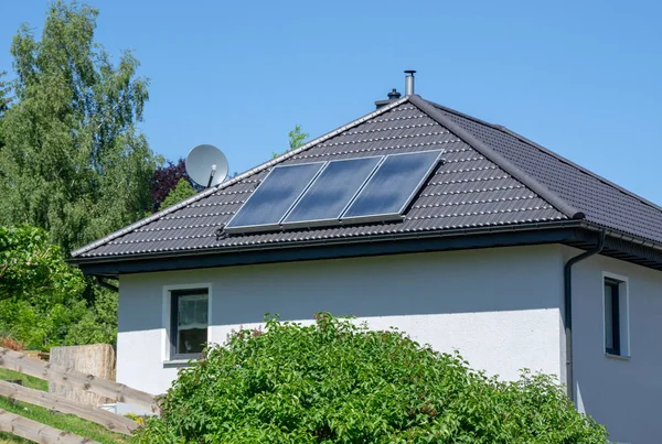 タイル張りの屋根と太陽熱発電所を備えた家 — ストック写真
