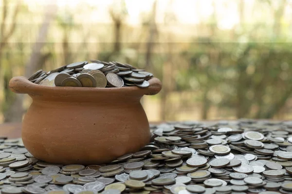 Coins in jar on wooden with blurred background, Money stack for business planning investment and saving concept