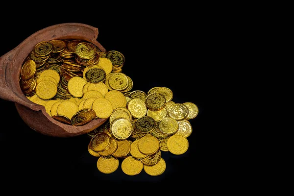 Stacking gold Coin in broken jar on black background,