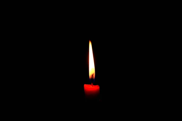 一支点燃的火焰蜡烛在黑色背景上明亮燃烧 — 图库照片
