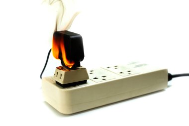 Ateşe elektrikli tel fiş priz ve bağdaştırıcı üzerinde beyaz arka plan, yanmış elektrik tel kaynaklanan elektrik kısa devre hatası