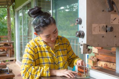 Kontrol için reşin çam kozalağı tutan kadın