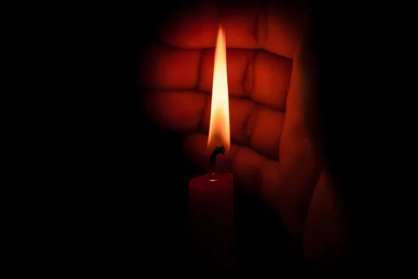 Mão protegendo a luz da vela do vento — Fotografia de Stock