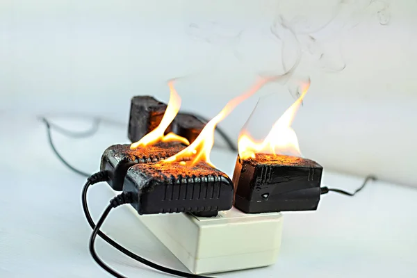 On fire Adapter an Steckdose auf weißem Hintergrund — Stockfoto