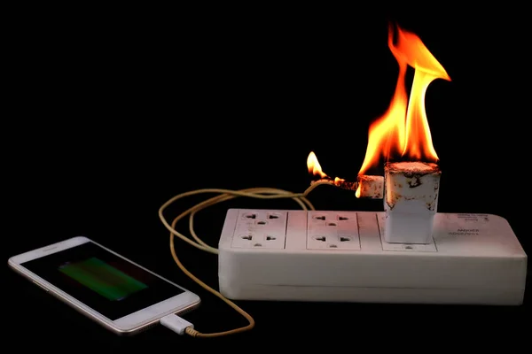 På Fire adapter smart telefon laddare på plug in eluttag — Stockfoto