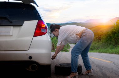 Bir yedek araba lastik o tutan resmi giyim genç çekici kadın