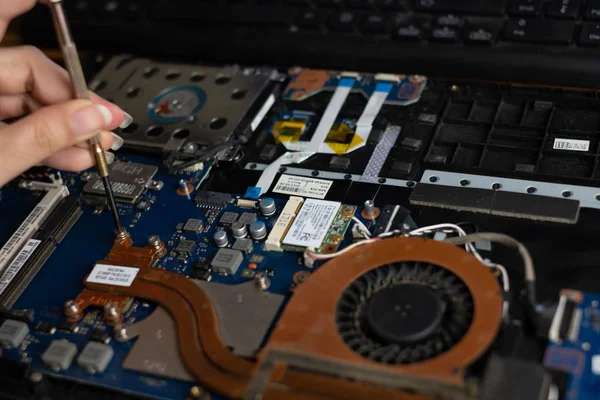 Technician repairing broken laptop notebook computer