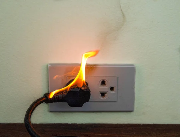 On fire electric wire plug Receptacle wall partition — Stock Photo, Image