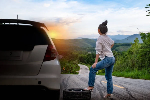 Genç güzel bayan t yardım çağrısı için arabanın yanında duran