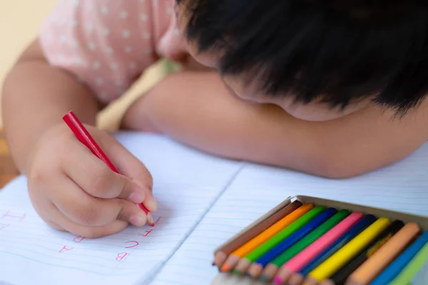 Close up of girl hand with pencil writing english words by hand — Stock Photo, Image
