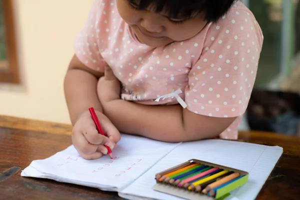 Close up of girl hand with pencil writing english words by hand — Stock Photo, Image