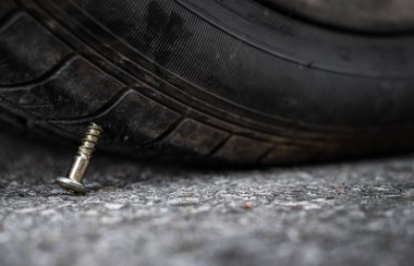 Kapat düğme başlı iğne metal çivi yolda tekerlek lastiğine saplandı