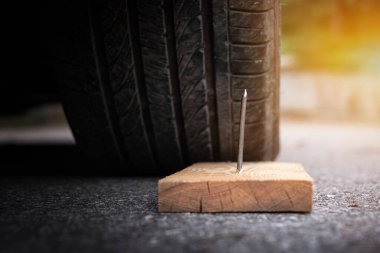 Tekerlek lastiğini delmek için tahta çiviyi kapat.