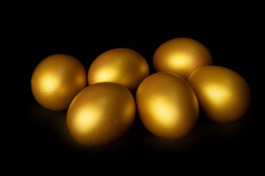 Altın yumurta siyah arkaplanda izole edilmiş.