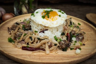 Kızarmış et ve bambu filizi ve haşlanmış pirinçli yumurta ile servis edilen kutsal fesleğen.