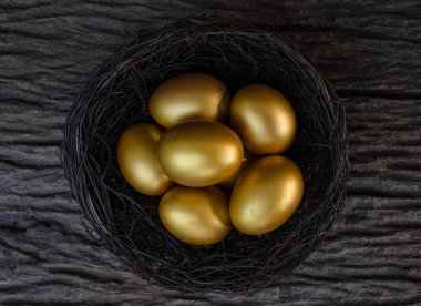 Eski ahşap masadaki yuvada altın yumurtalar