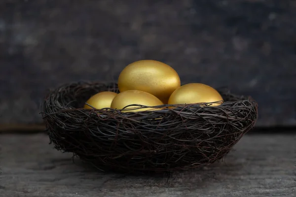 Golden eggs in a nest on the old wood tabl