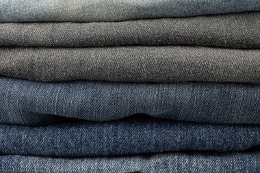 Beyaz arkaplanda çeşitli kot pantolonlar var.