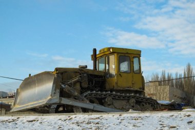 Kirli sarı buldozer. Kış yolda inşaat durdu çünkü.
