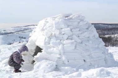 Çocuk Eskimolar Igloo ev görünüyor.