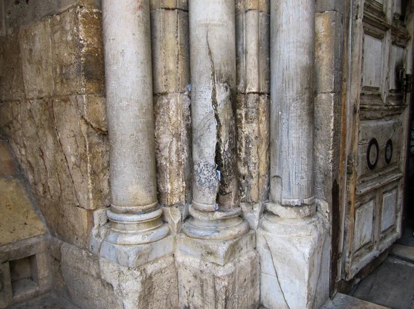 The stone pillars by the entrance to The Church of the Holy Sepulchre. In the cracks of the pillars some believers and pilgrims insert prayer notes. Jerusalem, Israel.