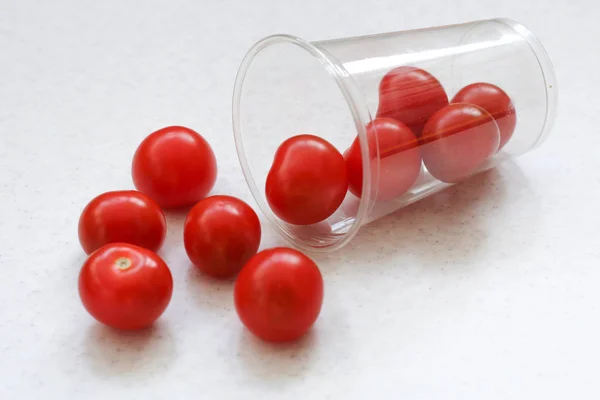 Mehrere Leuchtend Rote Reife Kirschtomaten Gerollt Aus Einem Transparenten Plastikglas — Stockfoto