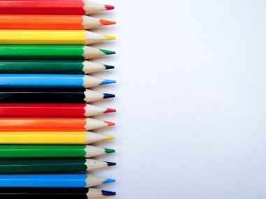 Aynı boyutta çok renkli parlak kalem düz beyaz kağıt, Gökkuşağının renkleri tarafından ayrılmış yalan. arka plan