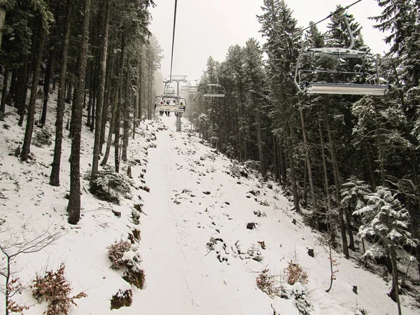 숲에서 케이블카로 기울기가 올라가서 스키어 — 스톡 사진