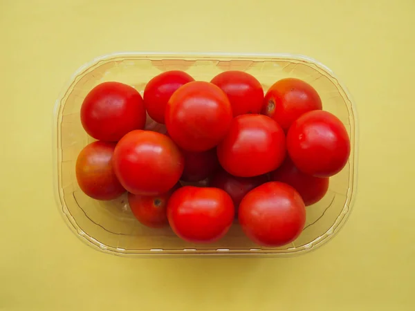 Caja Plástico Transparente Tomates Cherry Sobre Fondo Amarillo —  Fotos de Stock