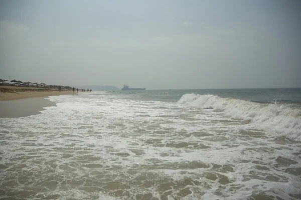 Hermosa vista de una enorme playa y olas y un viejo barco varado — Foto de Stock