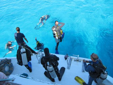 Sharm El Sheikh, Mısır - 29 Aralık 2009: dalgıçlar Kızıldeniz beyaz bir yat tarafındaki güzel turkuaz okyanusa atlamak