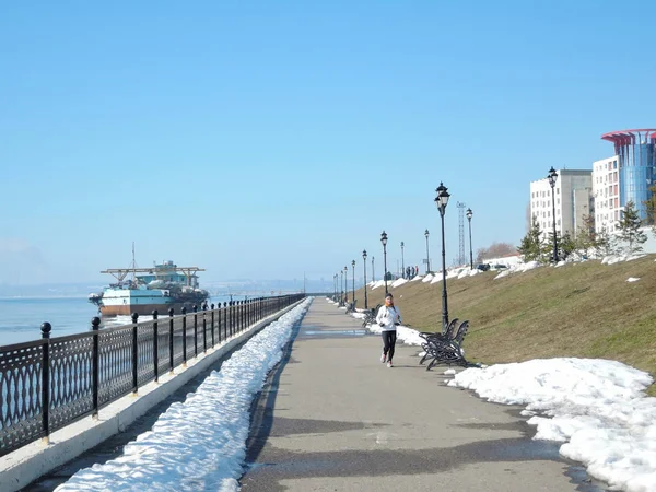 Een meisje in een sport-uniform is betrokken bij lopen, ze loopt langs de kust van de lente op een lentedag. Saratov Rusland - 30 maart 2019. — Stockfoto