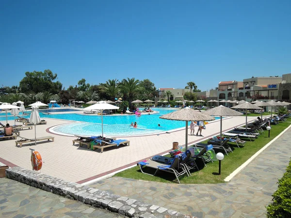 Kreta, Griekenland - 15 juni 2017: Prachtig uitzicht van het hotel met zwembad, ligstoelen en gezinnen — Stockfoto