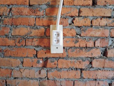 beyaz elektrik prizi soketli kırmızı tuğla duvar