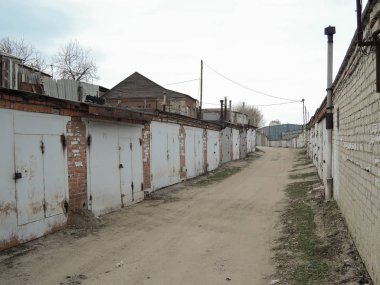 Kooperatifin metal kapıları olan tuğla garajlar.