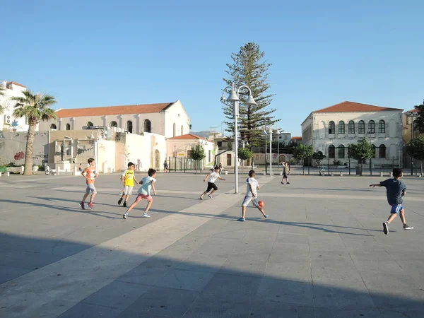 Rethymno, Řecko-15. června 2017: chlapci Teenageři různých národností hrající fotbal za slunečného večera v centru města — Stock fotografie
