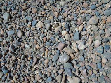 Güneşli bir günde arka planda renkli çakıl taşı